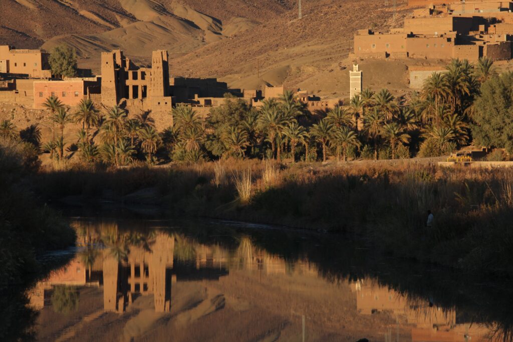 A picturesque village in Agdz, Morocco, reflecting in the Draa River at sunset.